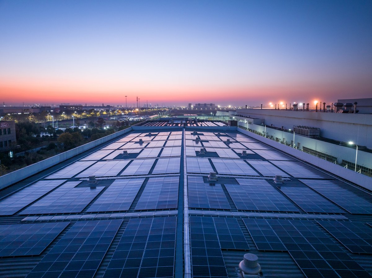 Solar power panels mounted across a rooftop under open sky