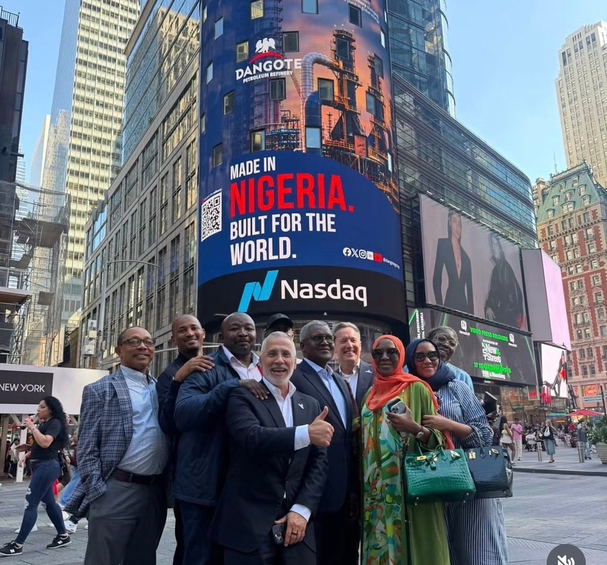 Group of professionals posing in Times Square in front of a Nasdaq billboard displaying Made in Nigeria, Built for the World message